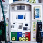 Close de uma bomba de combustíveis com opções de gasolina e diesel em um posto.